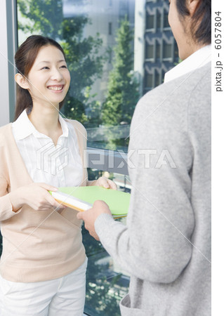 男性からファイルを受け取る女性 男性からファイルを受け取る女性 6057804