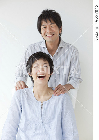 笑顔の女性の肩に手を置く男性の写真素材