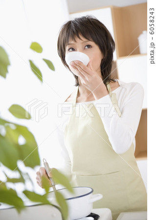 小皿で味見をする20代主婦 6058243