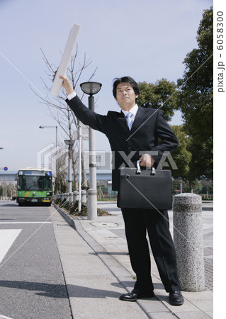 タクシーを止めるスーツ姿の男性 6058300