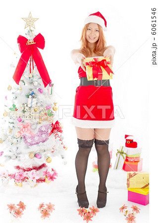 クリスマスツリーとプレゼントを差し出すキュートでセクシーなサンタさん クリスマスツリーとプレゼントを差し出すキュートでセクシーなサンタさん 6061546