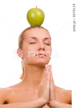 Beautiful blond girl with a green apple on head 6079119