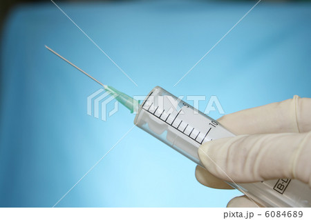 syringe in hand on blue syringe in hand on blue 6084689