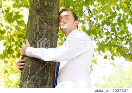 Businessman hugging tree Businessman hugging tree 6087284