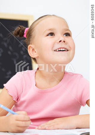 Little girl is writing using a pen 6089348