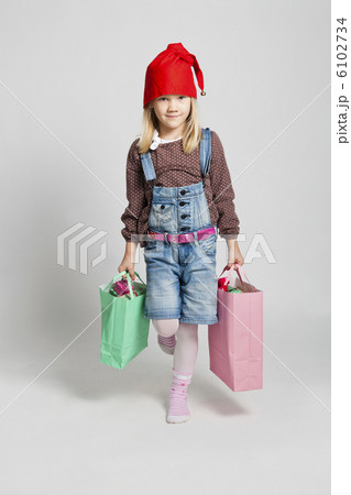 Happy young girl carrying Christmas shopping bags Happy young girl carrying Christmas shopping bags 6102734