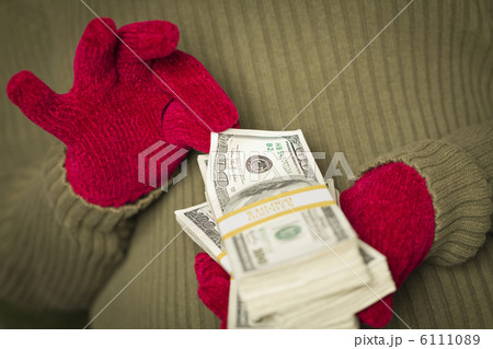 Woman Wearing Mittens Holding Stacks of Money with Red Ribbon Woman Wearing Mittens Holding Stacks of Money with Red Ribbon 6111089