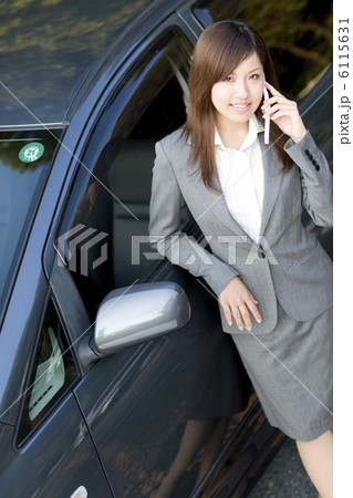 自動車にもたれて電話をかけるビジネスウーマン 自動車にもたれて電話をかけるビジネスウーマン 6115631