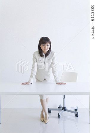 机に手を置くスーツを着た女性の写真素材