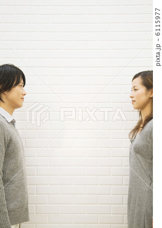 向かい合わせになっているカップル 6115977