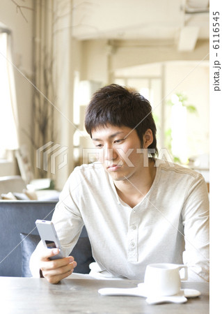 携帯電話を見て少し怒った表情の男性 6116545
