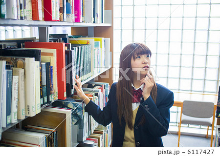 図書館で本を探す女子高生の写真素材