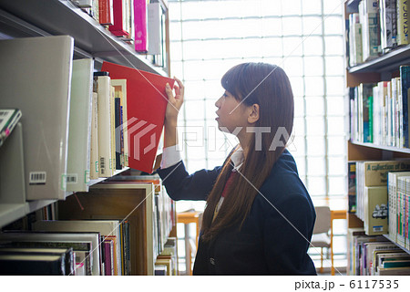 図書館で本を探す女子高生の写真素材