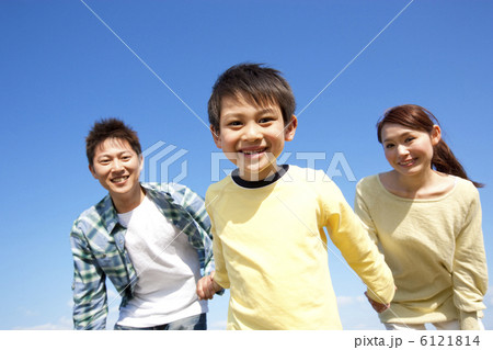 青空と手をつないでいる親子 6121814