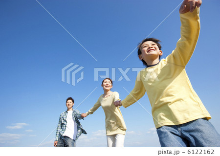 青空と手をつないでいる親子 6122162