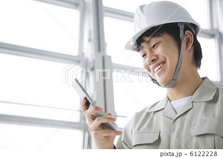携帯電話を見ている作業員の男性 6122228