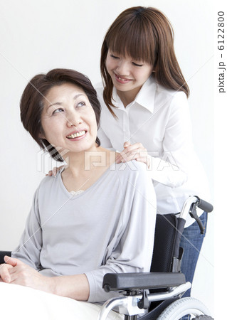 シニア女性の乗った車イスと若い女性 6122800