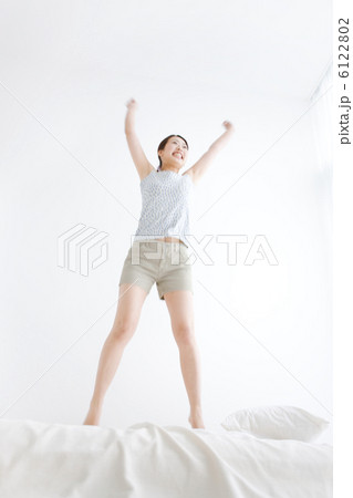 ベッドでジャンプしている女性 6122802