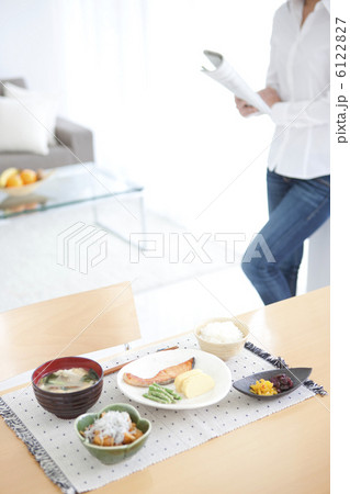 食卓と新聞を読む若い女性 6122827
