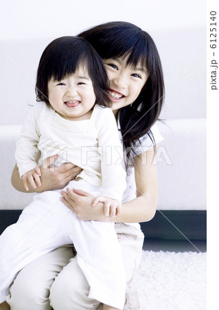 赤ちゃんを抱っこする女の子の写真素材