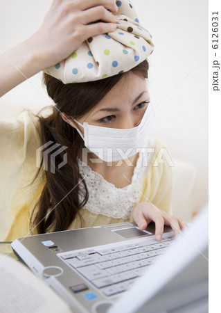 頭を冷やしてマスクしてパソコンする女性 6126031