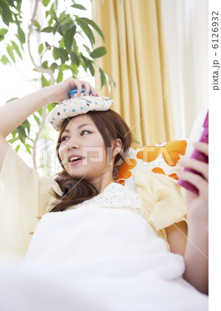 頭を冷やして携帯電話を持つ女性 6126932