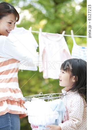 洗濯物を干している母親とお手伝いする女の子 洗濯物を干している母親とお手伝いする女の子 6127215