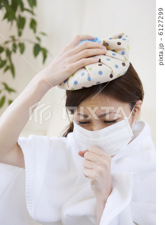 氷のうで頭を冷やして咳き込む女性 氷のうで頭を冷やして咳き込む女性 6127299