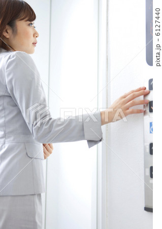 エレベーターのボタンを押すビジネスウーマン 6127440