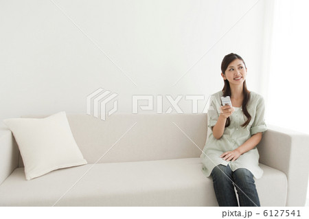 ソファに座って携帯電話を持っている女性 ソファに座って携帯電話を持っている女性 6127541