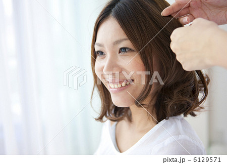 髪をセットしてもらう女性 6129571