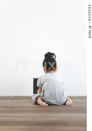 パソコンを操作する女の子の後姿の写真素材