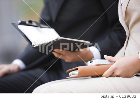 手帳を持つビジネスマンとビジネスウーマンの手元 6129632