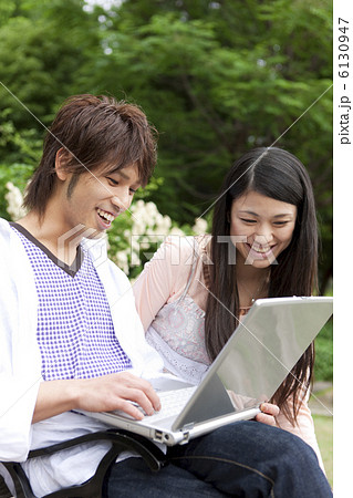 公園でパソコンをする日本人カップル 公園でパソコンをする日本人カップル 6130947