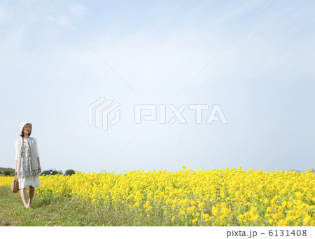 菜の花畑を歩く女性 6131408