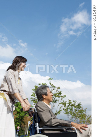 夫が乗っている車イスを押す妻 6131497