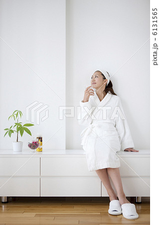 グラスを持って座るバスローブ姿の女性 6131565