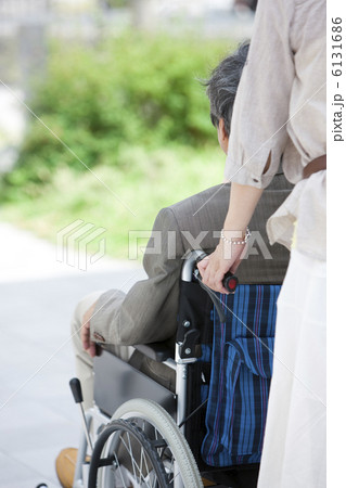 夫が乗っている車イスを押す妻 6131686