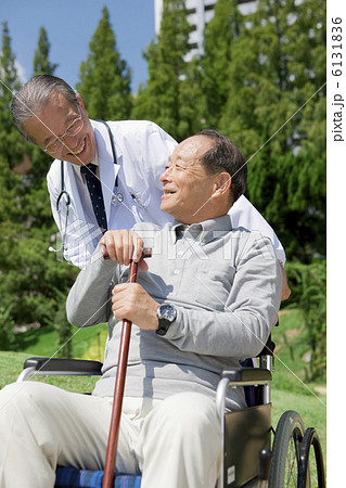 車いすの中高年男性と男性医師 6131836