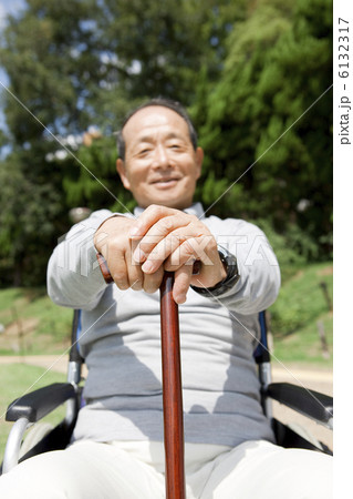 車いすに乗って杖を握る中高年男性 6132317
