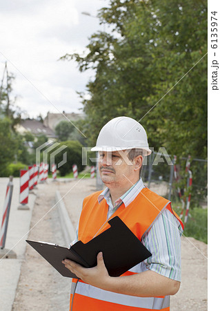 修理歩道の近くにフォルダを持つエンジニア 6135974