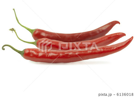 白い背景の上の行の3つの赤唐辛子 白い背景の上の行の3つの赤唐辛子 6136018