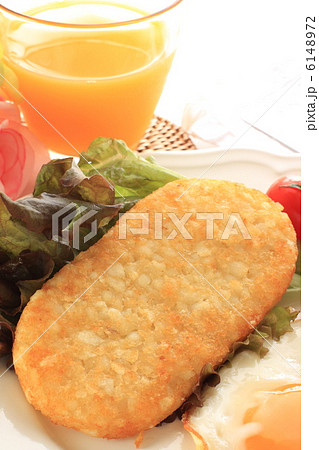 ハッシュブラウンポテトとオレンジジュースの朝食の写真素材