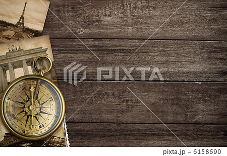 brass antique compass on table with old postcards and landmarks brass antique compass on table with old postcards and landmarks 6158690