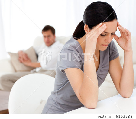 Man looking at his girlfriend having a headache sitting at a tab 6163538