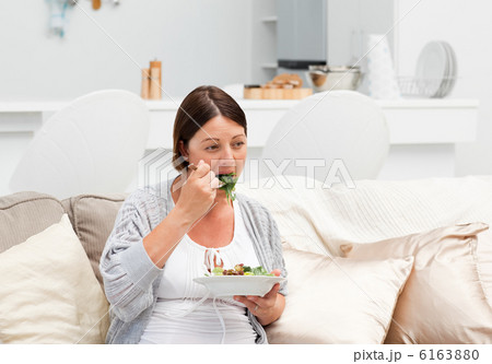 Pregnant woman eating vegetables Pregnant woman eating vegetables 6163880