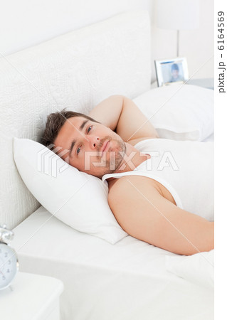 A relaxed man in his bed before waking up 6164569