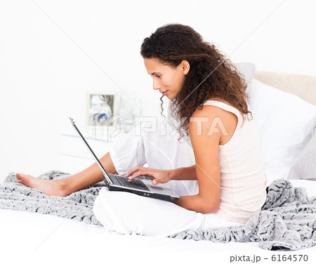 Pretty woman working on her laptop on her bed 6164570