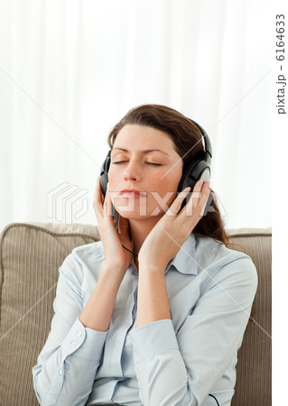 Concentrated woman listening music on the sofa 6164633