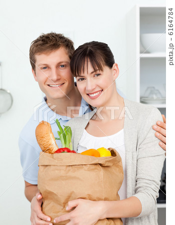 Lovely couple looking at the camera with their shoping bags 6164784